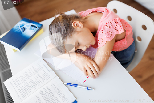 Image of tired student girl sleeping on table at home