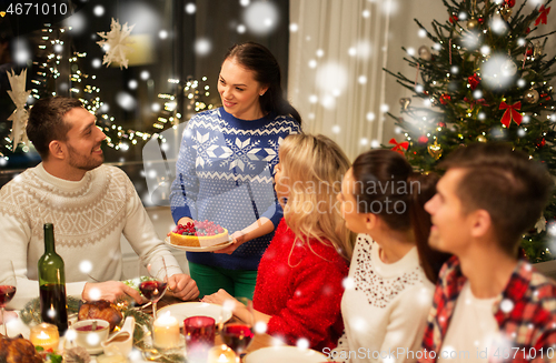 Image of happy friends having christmas dinner at home