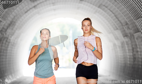 Image of women or female friends with earphones running