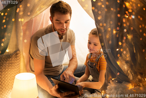 Image of family with tablet pc in kids tent at home