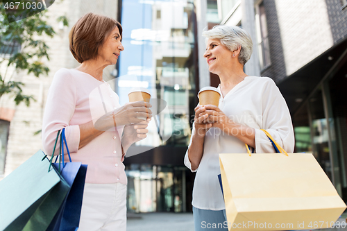 Image of senior women with shopping bags and coffee in city