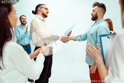 Image of Boss approving and congratulating young successful employee