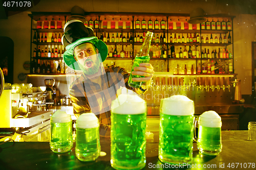 Image of Happy man with glass of beer looking aside in pub