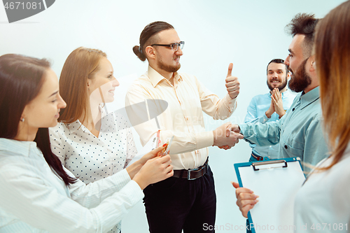 Image of Boss approving and congratulating young successful employee