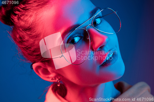 Image of Fashion pretty woman with headphones listening to music over neon background