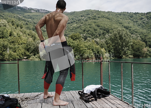 Image of triathlon athlete getting ready for swimming training on lake