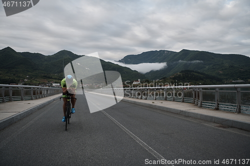 Image of triathlon athlete riding a bike on morning training