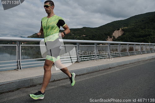 Image of triathlon athlete running on street