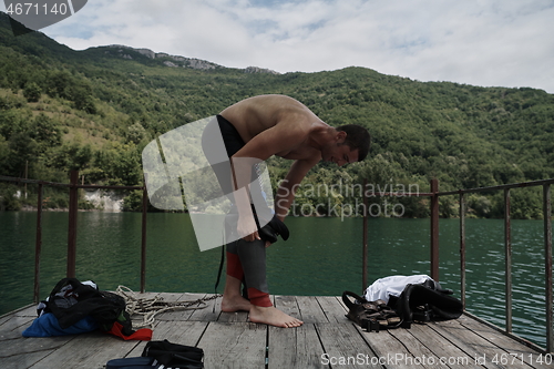 Image of triathlon athlete getting ready for swimming training on lake