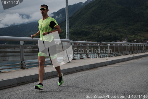 Image of triathlon athlete running on street