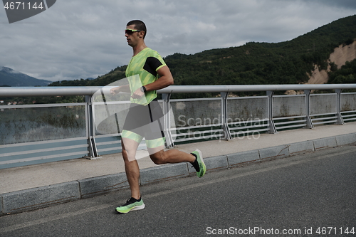 Image of triathlon athlete running on street