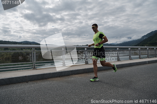 Image of triathlon athlete running on street