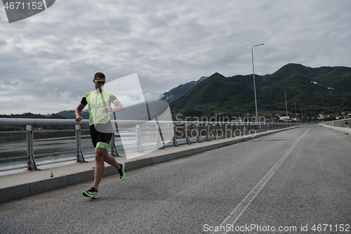 Image of triathlon athlete running on street