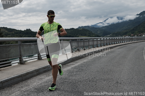 Image of triathlon athlete running on street