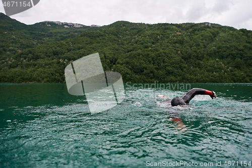 Image of triathlon athlete swimming on lake wearing wetsuit