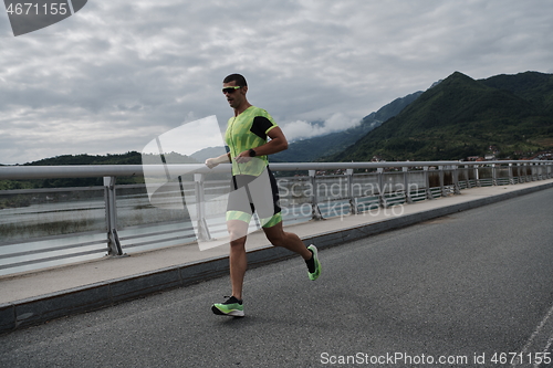 Image of triathlon athlete running on street