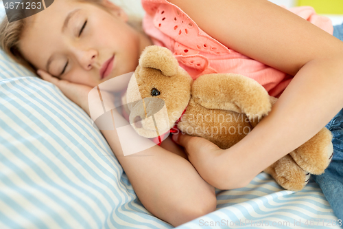 Image of little girl sleeping with teddy bear toy at home