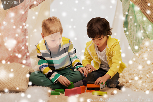 Image of boys playing toy blocks in kids tent at home