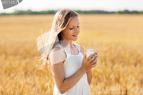 Image of girl with glass of milk on cereal field