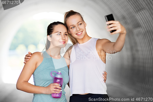 Image of sporty women taking selfie by smartphone outdoors