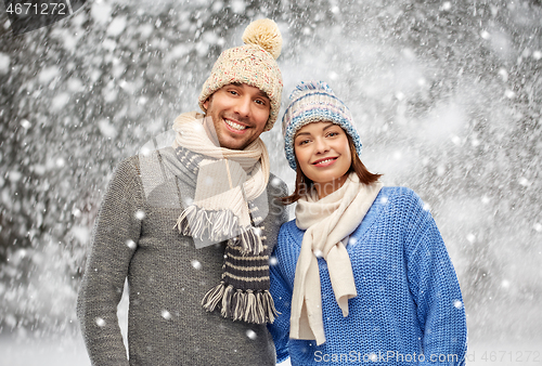 Image of happy couple in winter clothes over snow