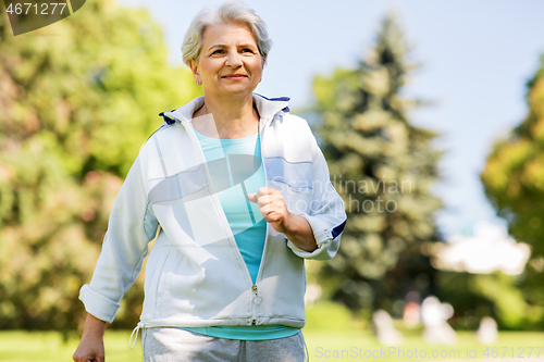 Image of senior woman running along summer park