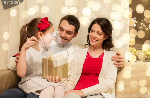 Image of happy family with christmas present at home