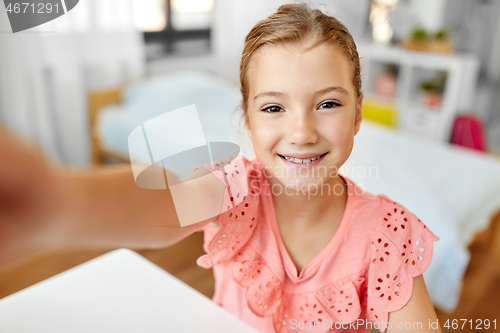 Image of happy girl taking selfie at home