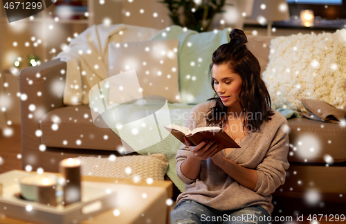 Image of happy young woman reading book at home