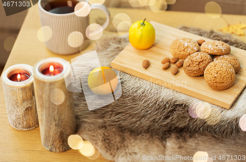 Image of cookies, lemon tea and candles on table at home