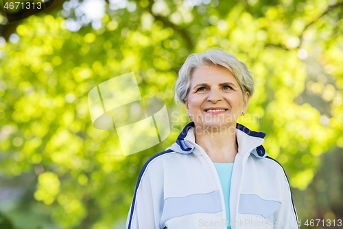 Image of smiling sporty senior woman at summer park