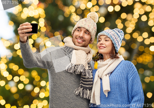 Image of couple taking selfie by smartphone on christmas