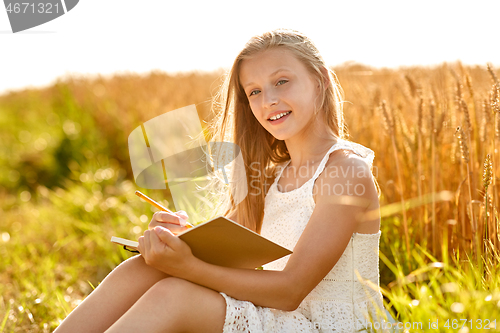 Image of smiling girl writing to diary on cereal field