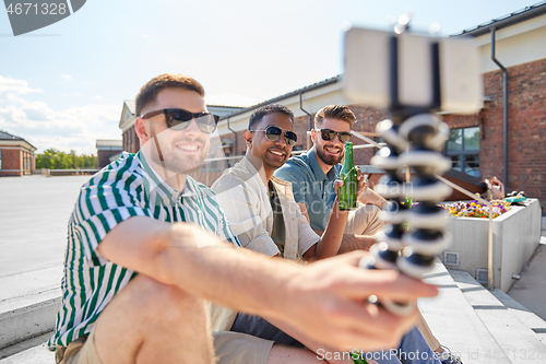 Image of men drinking beer and taking selfie by smartphone