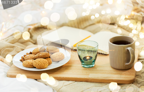 Image of cookies, tea and candle in holder at home