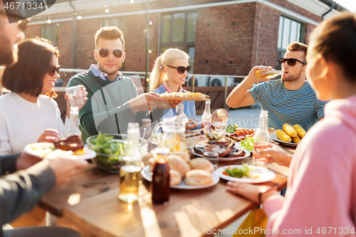 Image of friends having dinner or bbq party on rooftop