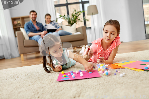 Image of happy sisters doing arts and crafts at home