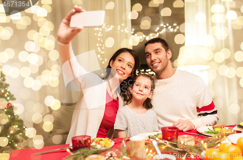 Image of happy family taking selfie at christmas dinner