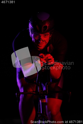 Image of triathlon athlete riding bike fast at night