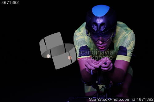 Image of triathlon athlete riding bike fast at night