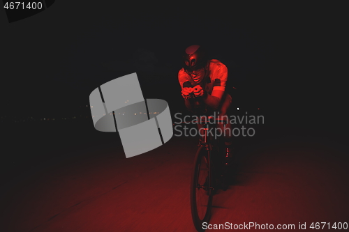 Image of triathlon athlete riding bike fast at night