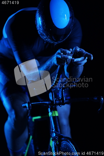 Image of triathlon athlete riding bike fast at night