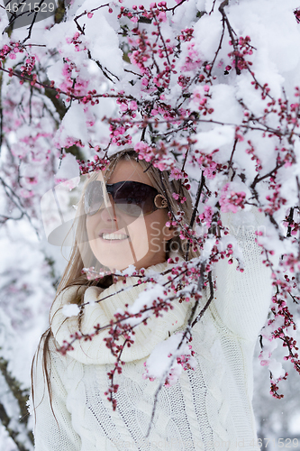 Image of Woman by cherry blossom tree in snow