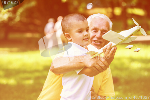 Image of grandfather and child have fun  in park