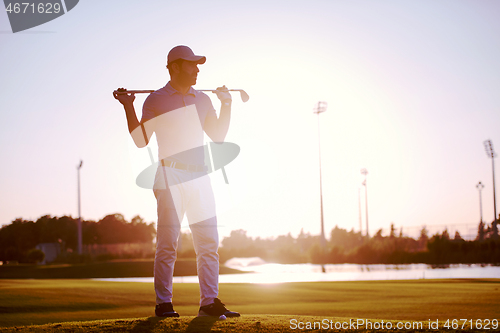 Image of golfer  portrait at golf course on sunset