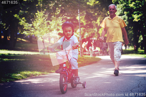 Image of grandfather and child have fun  in park
