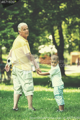 Image of grandfather and child have fun  in park