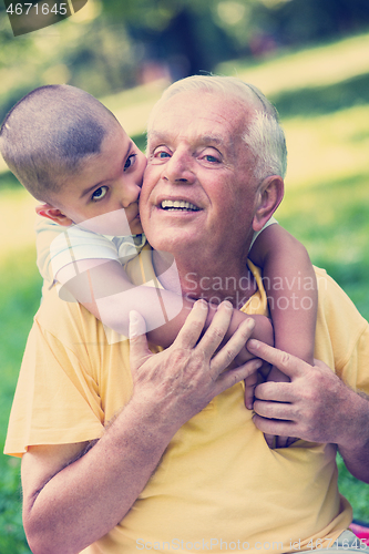 Image of grandfather and child have fun  in park