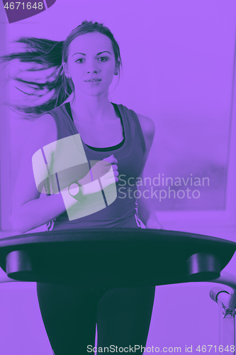 Image of womanworkout  in fitness club on running track machine