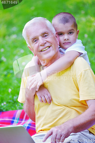 Image of grandfather and child using laptop